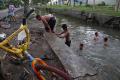 Tak Hiraukan Air Keruh, Anak-anak Ini Asik Bermain di Sungai Surabaya